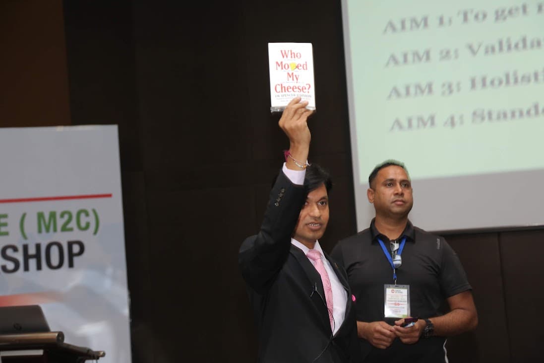 A speaker at a workshop holding up a book during an early Forces Network event
