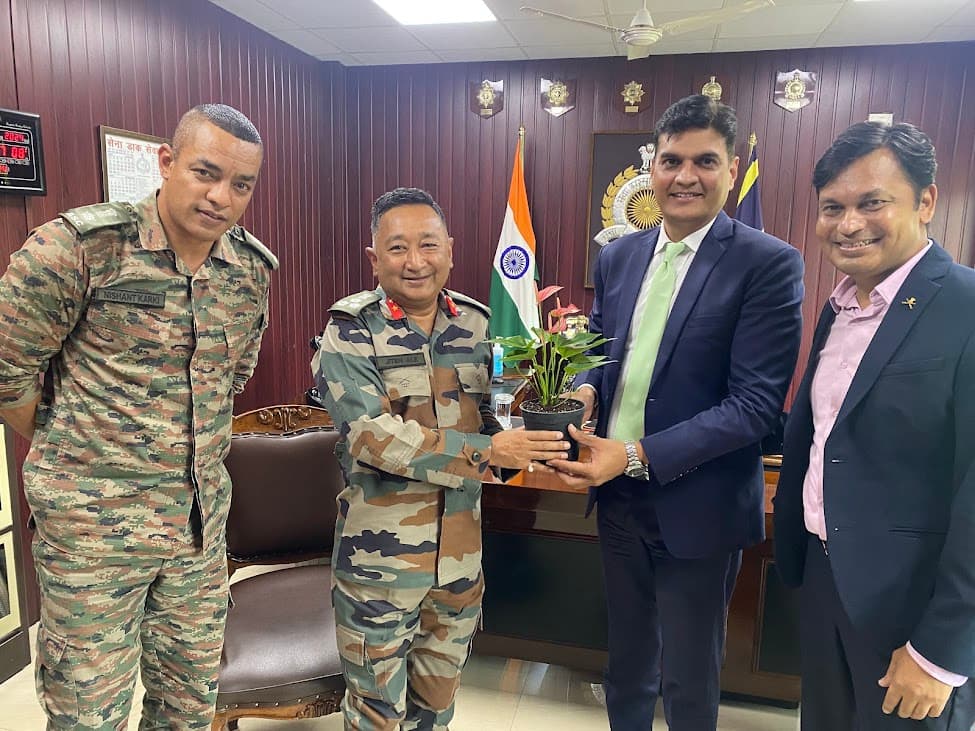 Army officers and business leaders exchanging a plant