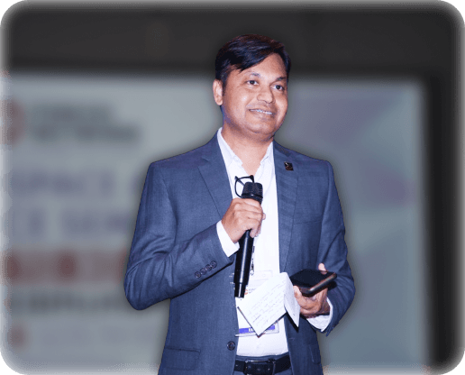Capt Uday K. Shriwas speaking while holding a microphone at an event