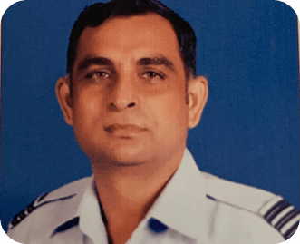 Wg Cdr Pushpendra Dhaka standing on an airstrip in front of a fighter aircraft