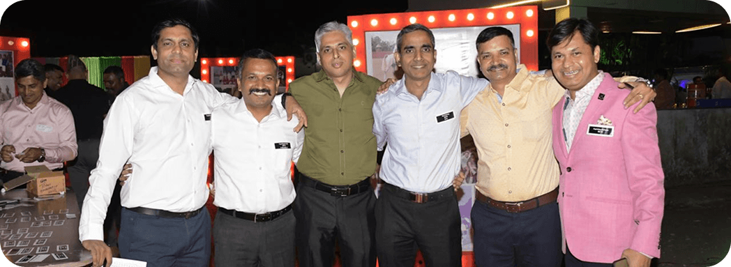 Six professionals posing together during an evening networking event