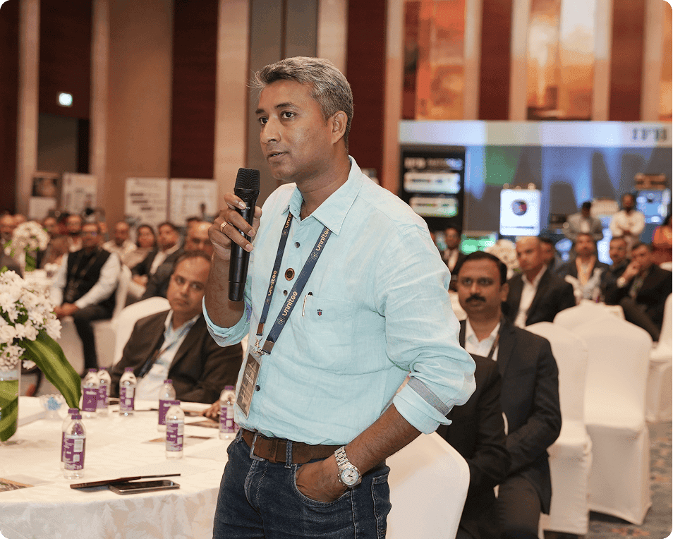 Capt Uday K. Shriwas posing with a group of professionals at an indoor networking event